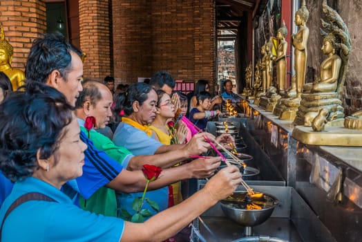 Bangkok, Thailand - December 29, 2013: people lighting incense at Wat Yai Chaimongkol Ayutthaya in Bangkok, Thailand on december 29th, 2013