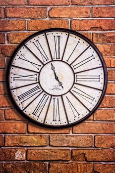 Detail of old vintage clock on textured brick wall