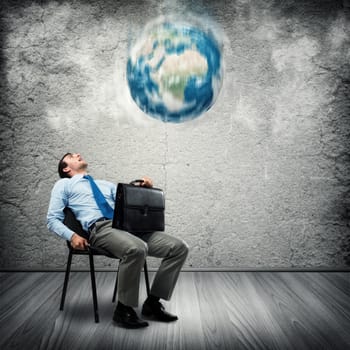 image of a business man looking at the falling planet. Elements of this image furnished by NASA