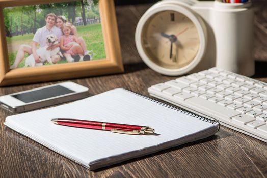 photo frame, mobile phone and notebook with a ballpoint pen. Workplace of the businessman.