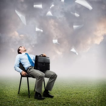 image of a business man looking at the falling paper