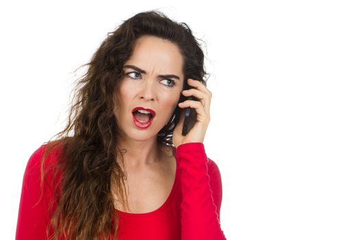 An annoyed and angry woman talking on the phone and looking unhappy. Isolated on white.