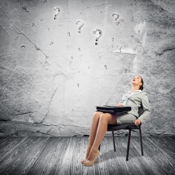 image of a young business woman looking at the question marks