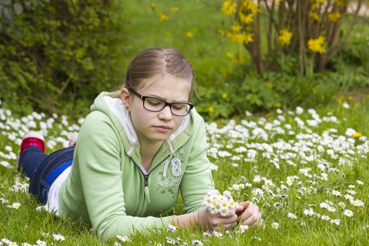 young girl picking daisies