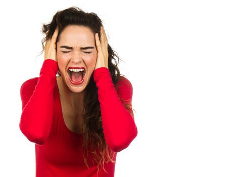 A very angry and frustrated woman screaming and covering her ears. Isolated on white.