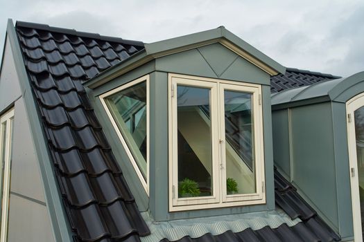Modern design vertical roof window with white light metal covering                               