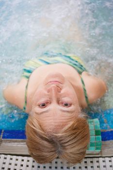 In aquapark. Smiling beautiful woman relaxing in pool.