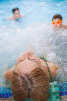 In aquapark. Smiling beautiful woman relaxing in pool.