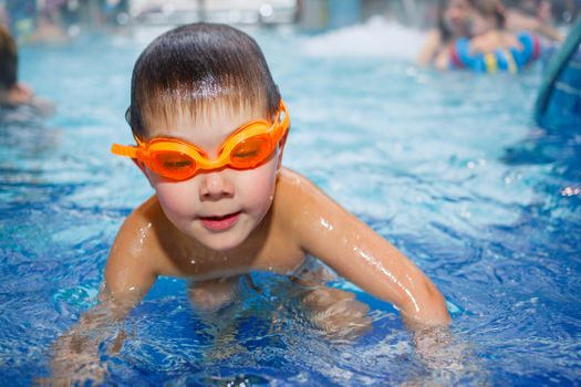 Activities on the pool. Cute boy in swimming pool