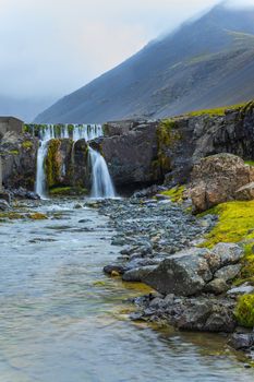 Cloudy sky over the amazing waterfall in Iceland. Vertical view