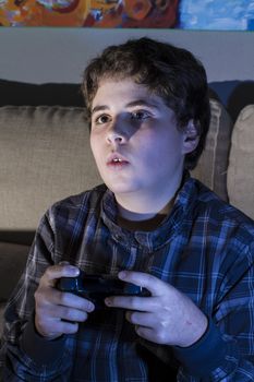 Entertainment. boy with joystick playing computer game at home.