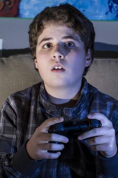 boy with joystick playing computer game at home.