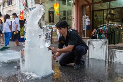 PHUKET, THAILAND - 07 FEB 2014: Unidentified men cut out icy horse for annual old Phuket town festival. 