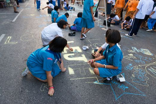 PHUKET, THAILAND - 07 FEB 2014: Unidentified kids draw by chalk on the central street during annual old Phuket town festival. 
