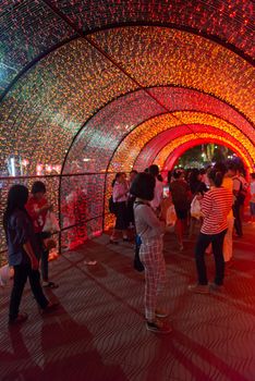 PHUKET, THAILAND - 07 FEB 2014: Unidentified people walk in red bright illuminated arch during annual old Phuket town festival at night. 