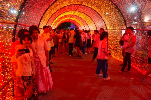 PHUKET, THAILAND - 07 FEB 2014: Unidentified people walk in red bright illuminated arch during annual old Phuket town festival at night. 