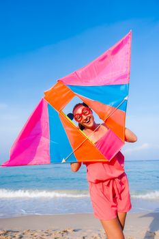 Sunrise beach side, Girl playing with kite and have a joy, smile. 