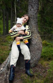 Portrait of Mother and Baby in the wild forest. Beautiful mother and little daughter walking together in summer forest