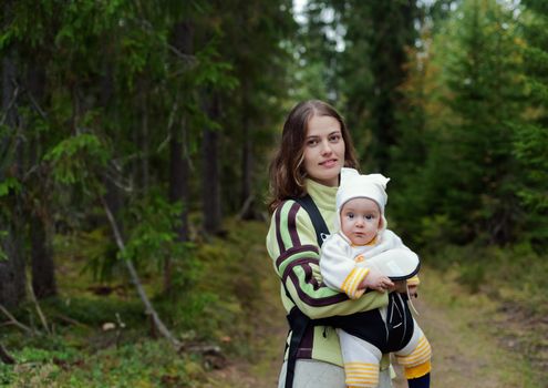 Portrait of Mother and Baby in the wild forest. Beautiful mother and little daughter walking together in summer forest