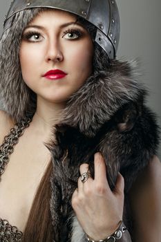 Attractive young girl with historical armor shot in studio