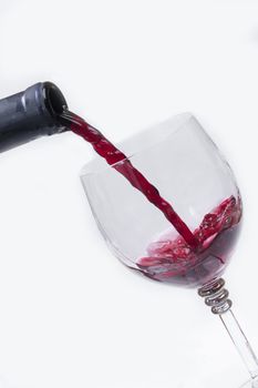 Stream of red wine on white background.