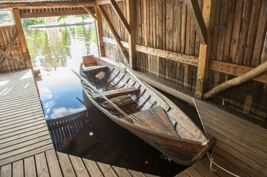 Wooden boat in the pier under canopy. Taken in Finland.
