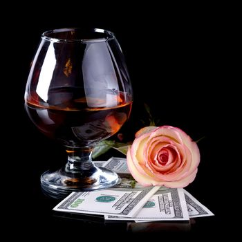 Glass, rose and money. Alcohol, flower and dollars. Glass with drink and a pink rose with dollars.