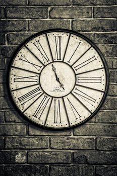 Detail of old vintage clock in monochrome on textured brick wall