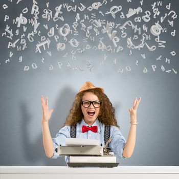 image of a young woman writer at the table with typewriter