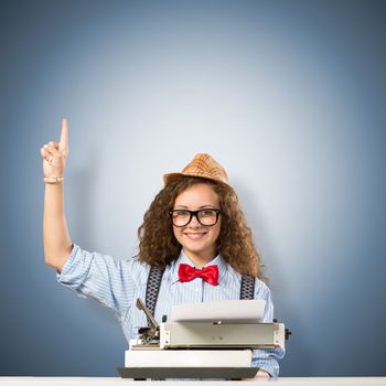 image of a young woman writer at the table with typewriter