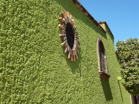 The living green wall of a house in Huatulco Crucecita, Mexico with decorative windows