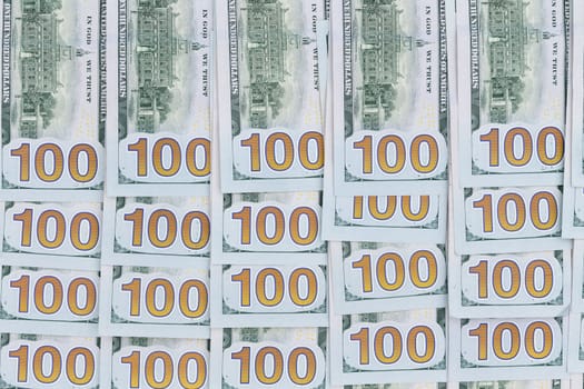 Neatly arranged background of American 100 dollar bills with all the numbers aligned in rows in a conceptual financial background, overhead view