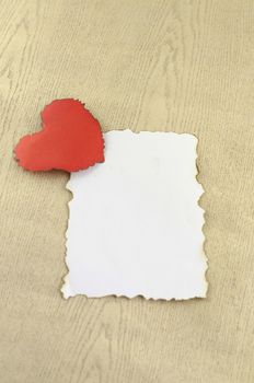 heart and white paper on wood background
