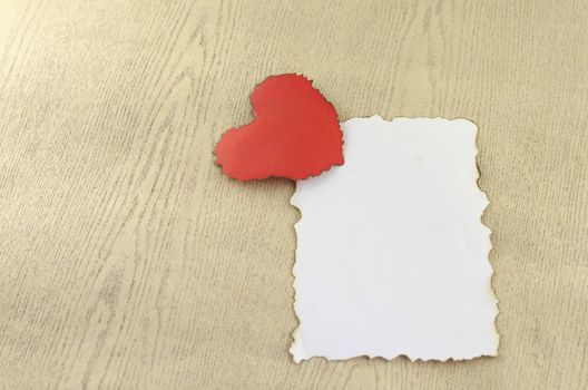 heart and white paper on wood background