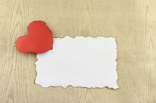 heart and white paper on wood background