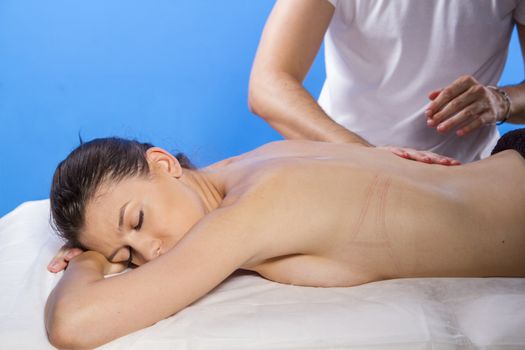Professional masseur doing massage on woman body in the spa salon. Beauty treatment concept.