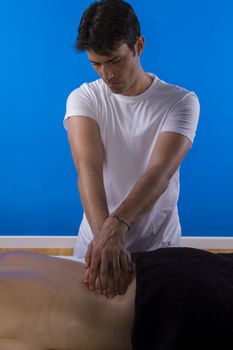 Professional masseur doing massage on woman body in the spa salon. Beauty treatment concept.