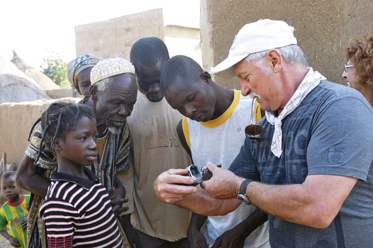 Sharing a French tourist watching her videos with the inhabitants of a village in Burkina Faso which he visited