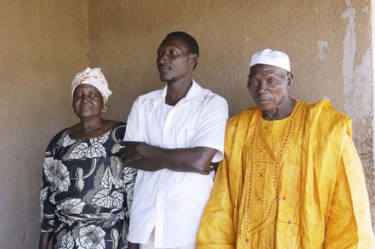 portrait of a son to his parents home in front of their house in Ouagadougou