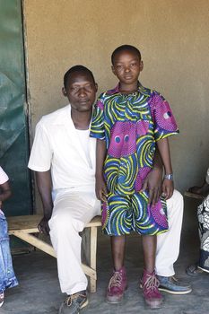 portrait of an African father and daughter outside his home in Ouagadougou