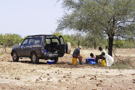 gold prospectors making a lunch break in the shade of a tree in the savannah of Burkina Faso