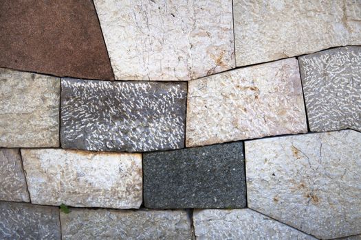 Stone wall with add shaped blocks and various colors and textures of stones