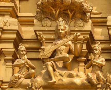 Detail of statues on the golden entrance tower at Sri Naheshwara in Bengaluru: Saraswati, goddess of knowledge and education.