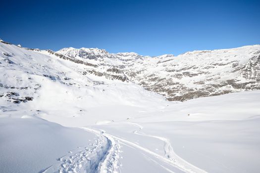 Tour ski tracks on snowy slope in winter scenic landscape