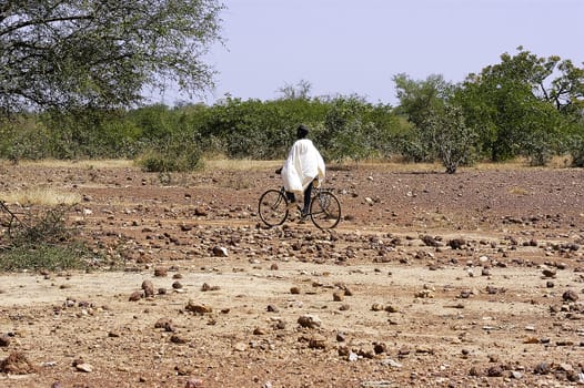 African cyclist on a trail through the savannah in Burkina Faso