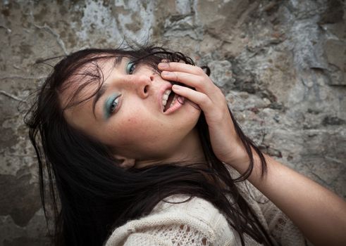 Portrait of a girl against old concrete wall