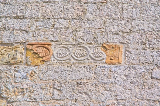 Part of the walls of the Old Church of red bricks in the mountains of Italy