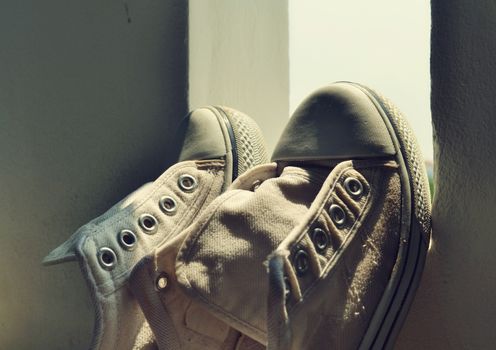 White sneakers placed on the windows in morning light