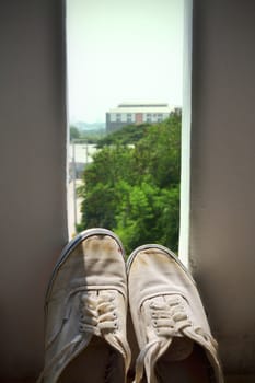 White sneakers placed on the windows in nature