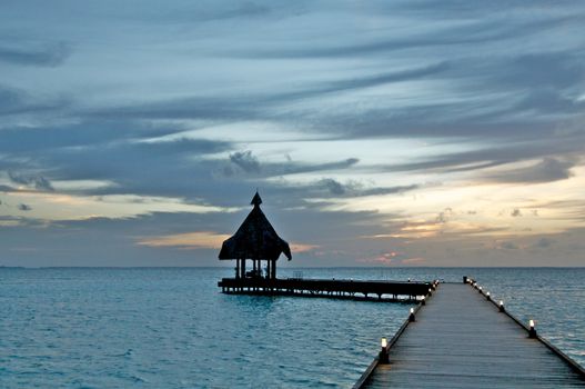 Tropical Jetty and Pier with Electric Lights on Ocean and Twilight Sky background
